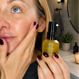 Woman applying a skincare product to her face in a bathroom setting