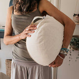 natural meditation and yoga cushion Zafu, held by yoga/meditation teacher